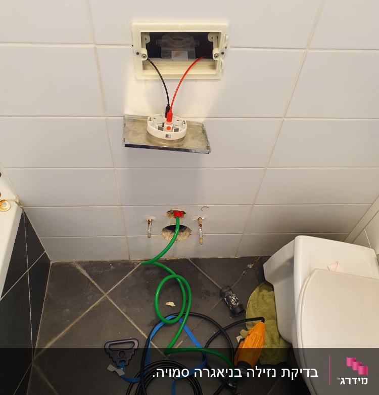 כלים וצינורות של אינסטלטור בחדר אמבטיה